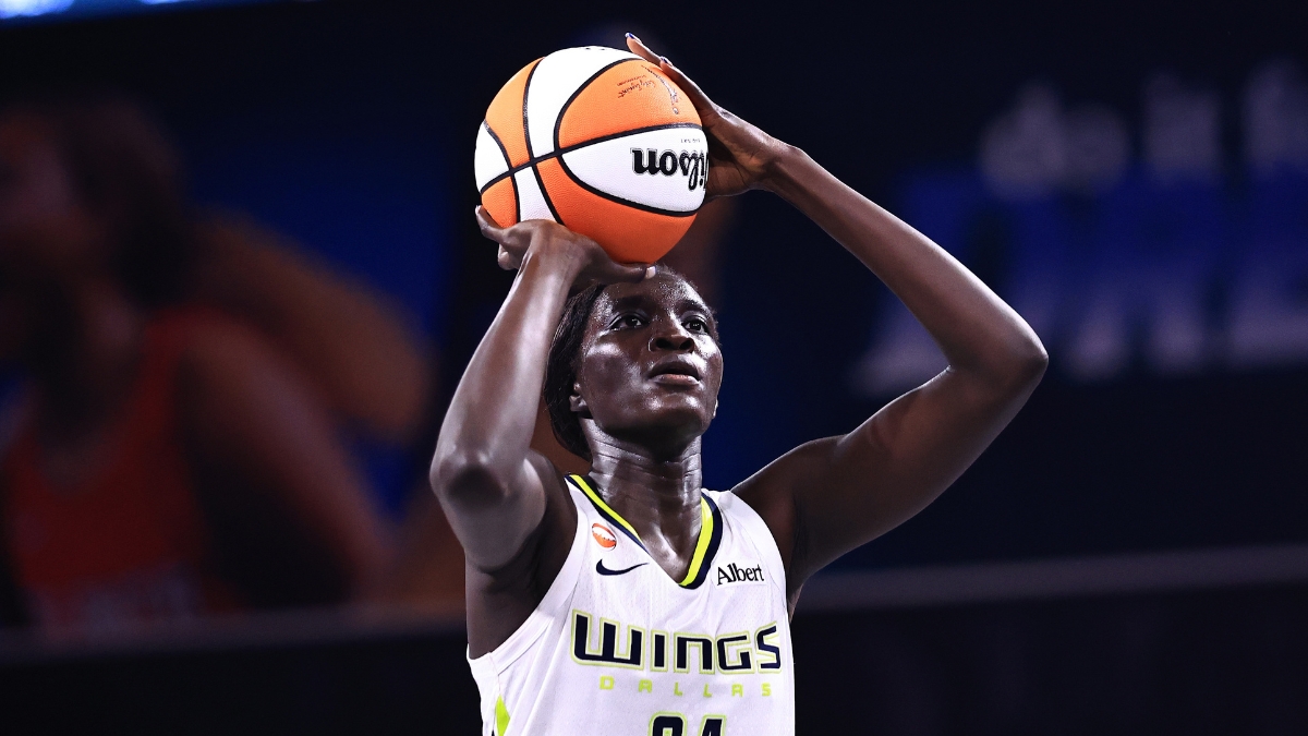 Forward Awak Kuier standing at the free-throw line, focusing on the rim with the ball balanced in her hands before launching her shot attempt.