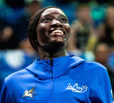 Forward Awak Kuier wearing a blue Dallas Wings warmup shirt while looking focused on the floor before a game.