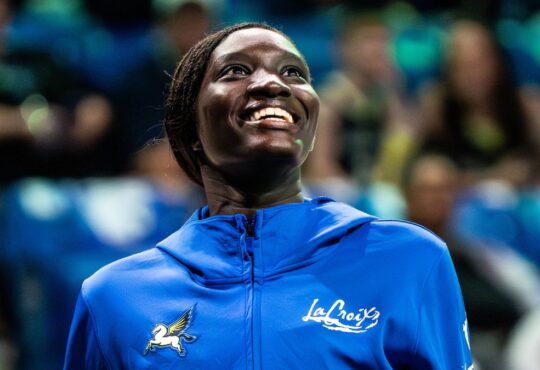Forward Awak Kuier wearing a blue Dallas Wings warmup shirt while looking focused on the floor before a game.
