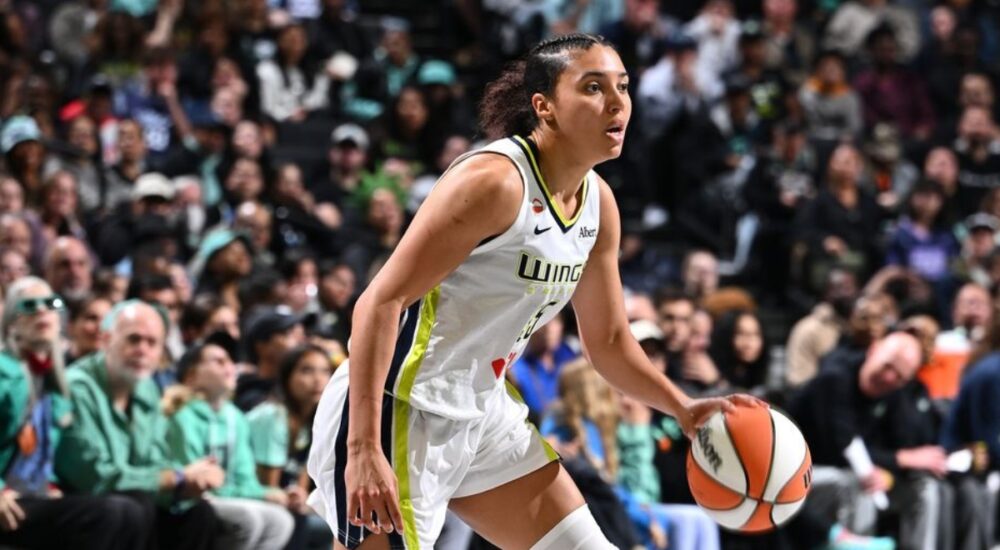Rookie guard Azzi Fudd dribbling the ball at the top of the key while reading the New York Liberty defense.