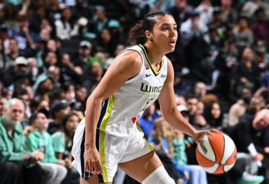 Rookie guard Azzi Fudd dribbling the ball at the top of the key while reading the New York Liberty defense.