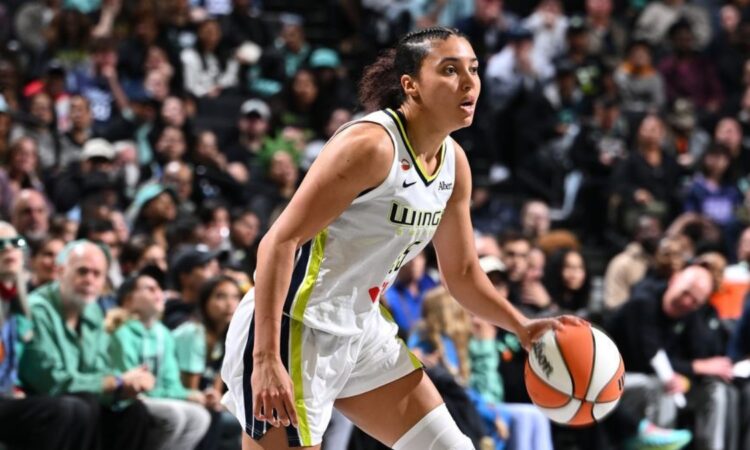 Rookie guard Azzi Fudd dribbling the ball at the top of the key while reading the New York Liberty defense.