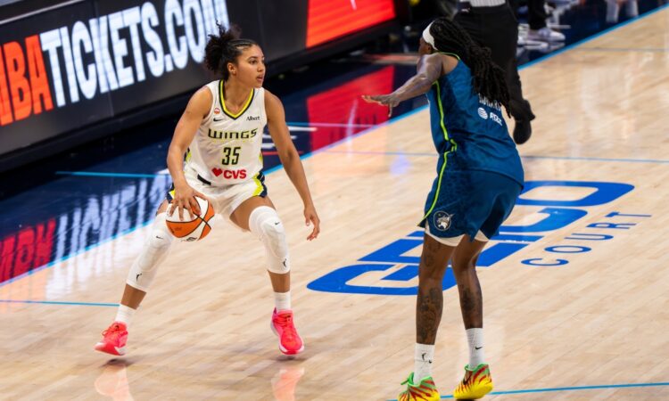 Rookie guard Azzi Fudd of the Dallas Wings handling the ball while being defended by Natasha Howard of the Minnesota Lynx.