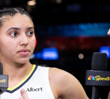 Rookie guard Azzi Fudd standing on the court at Barclays Center holding a microphone during a postgame interview.
