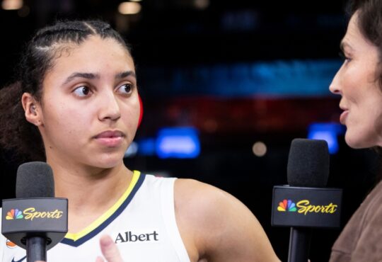 Rookie guard Azzi Fudd standing on the court at Barclays Center holding a microphone during a postgame interview.