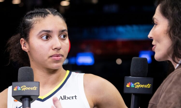 Rookie guard Azzi Fudd standing on the court at Barclays Center holding a microphone during a postgame interview.