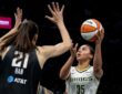 Rookie guard Azzi Fudd releasing a high-arcing jump shot over the contested challenge of center Han Xu.