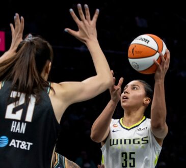 Rookie guard Azzi Fudd releasing a high-arcing jump shot over the contested challenge of center Han Xu.