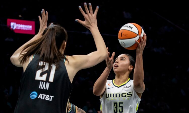 Rookie guard Azzi Fudd releasing a high-arcing jump shot over the contested challenge of center Han Xu.