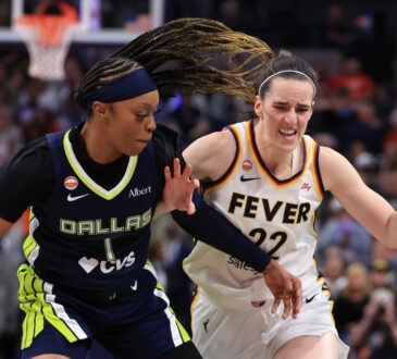 Caitlin Clark of the Indiana Fever brings the ball up the court against defensive pressure from Odyssey Sims of the Dallas Wings at Gainbridge Fieldhouse.