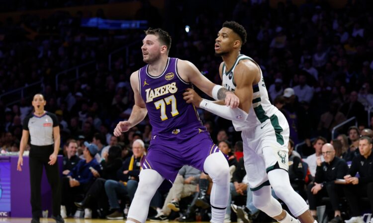 Giannis Antetokounmpo #34 of the Milwaukee Bucks and Luka Doncic #77 of the Los Angeles Lakers battle for position at Crypto.com Arena.
