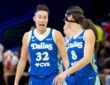 Jessica Shepard and Alanna Smith standing close together on the hardwood, talking and gesturing during a stoppage in play against the Washington Mystics.