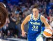 Jessica Shepard lowering her shoulder and dribbling the basketball with her right hand while driving past the tight perimeter defense of Kiki Iriafen.