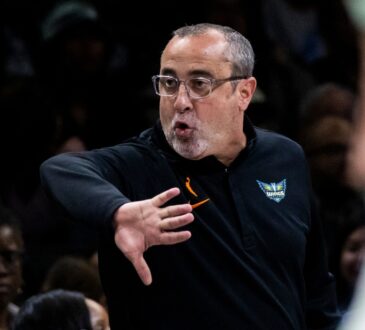 Head coach Jose Fernandez shouting instructions and gesturing toward his players from the sideline at Barclays Center.