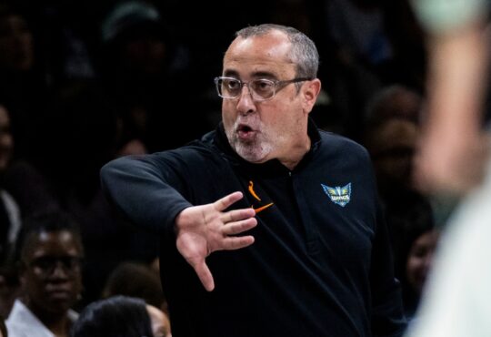 Head coach Jose Fernandez shouting instructions and gesturing toward his players from the sideline at Barclays Center.