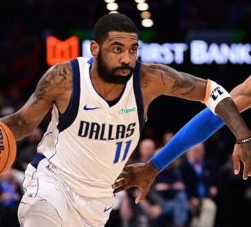 Guard Kyrie Irving wearing a blue Dallas Mavericks jersey while handling the ball on the perimeter against defender Jalen Williams of the Oklahoma City Thunder.