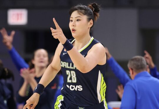 Li Yueru smiling and clapping in celebration on the court during the second half against the Chicago Sky.