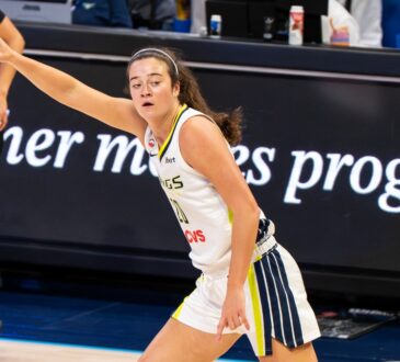 Maddy Siegrist of the Dallas Wings rising for a mid-range jump shot over Napheesa Collier of the Minnesota Lynx.