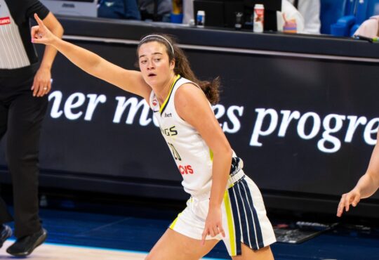 Maddy Siegrist of the Dallas Wings rising for a mid-range jump shot over Napheesa Collier of the Minnesota Lynx.