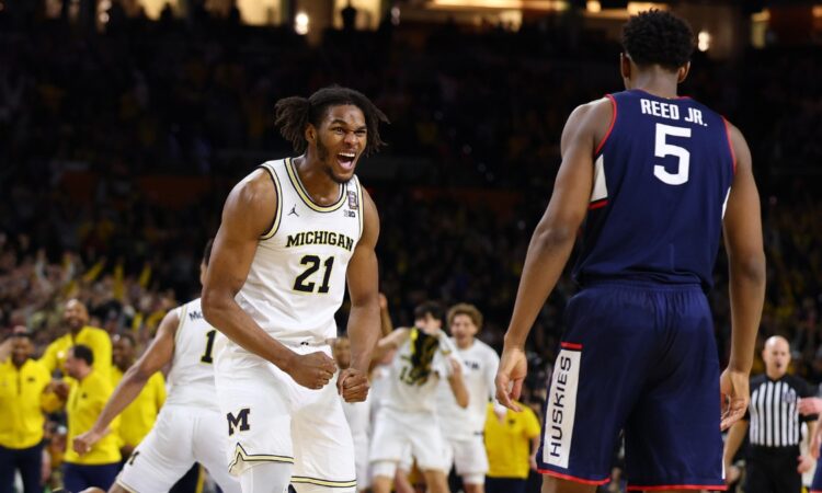 Michigan sophomore big man Morez Johnson Jr. screaming in celebration amidst falling confetti on the court after winning the national title.
