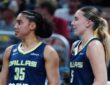 Paige Bueckers and Azzi Fudd watching from the bench during the Mavericks' preseason game against the Indiana Fever.