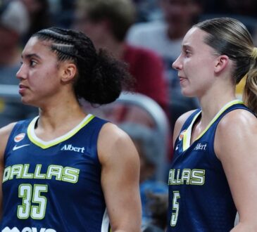 Paige Bueckers and Azzi Fudd watching from the bench during the Mavericks' preseason game against the Indiana Fever.