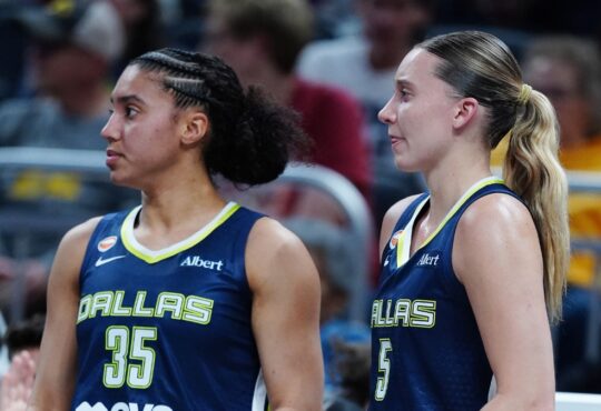 Paige Bueckers and Azzi Fudd watching from the bench during the Mavericks' preseason game against the Indiana Fever.