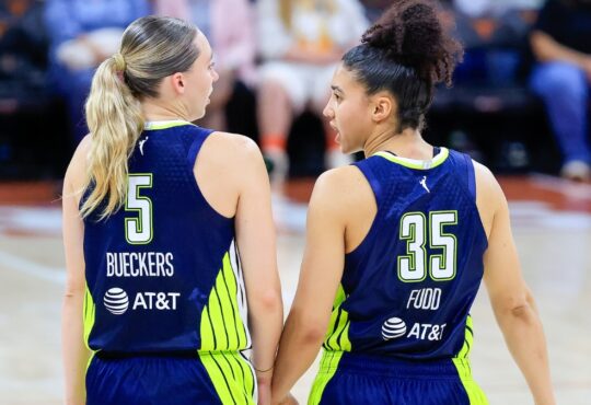 Paige Bueckers and Azzi Fudd talking on the court during the Wings vs. Aces preseason game.