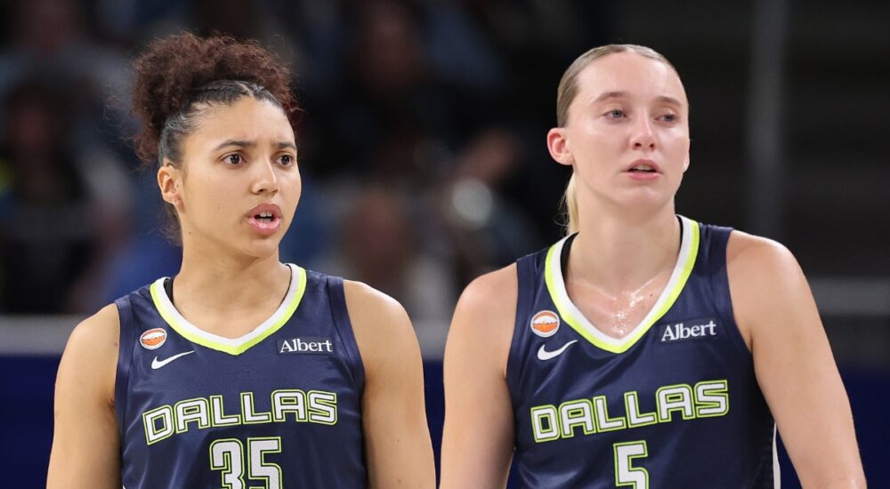 Guard Paige Bueckers and rookie guard Azzi Fudd looking on together from the floor during a game against the Chicago Sky.