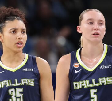 Guard Paige Bueckers and rookie guard Azzi Fudd looking on together from the floor during a game against the Chicago Sky.