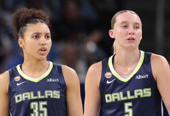 Guard Paige Bueckers and rookie guard Azzi Fudd looking on together from the floor during a game against the Chicago Sky.