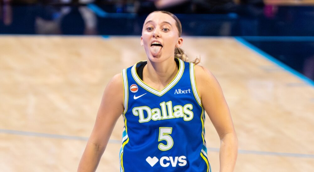 Guard Paige Bueckers celebrating on the court, smiling and gesturing dynamically after a successful offensive sequence.