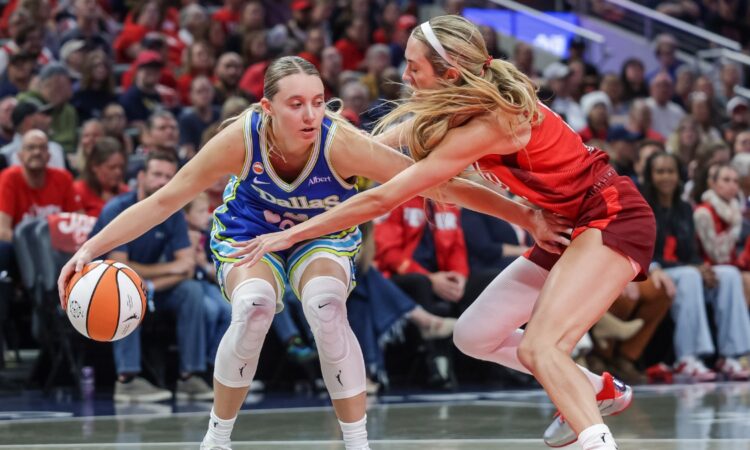 Paige Bueckers (5) of the Dallas Wings dribbles against Lexie Hull (10) of the Indiana Fever at Gainbridge Fieldhouse.