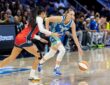 Guard Paige Bueckers of the Dallas Wings dribbling the ball at the perimeter against a Washington Mystics defender at College Park Center.