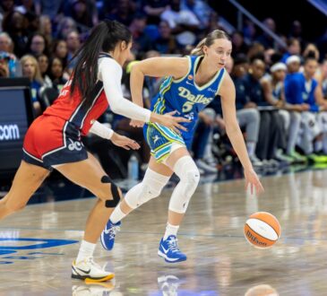 Guard Paige Bueckers of the Dallas Wings dribbling the ball at the perimeter against a Washington Mystics defender at College Park Center.