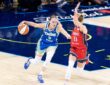 Paige Bueckers dribbling the basketball with her left hand while surveying the floor and advancing up the court under defensive pressure from Lucy Olsen.