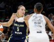 Guard Paige Bueckers driving hard downhill against the perimeter defense of center A'ja Wilson.