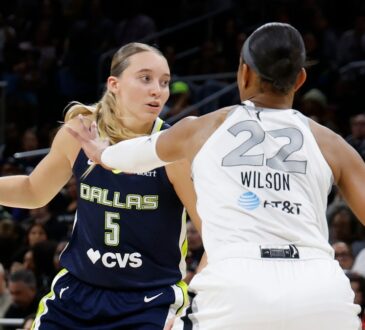 Guard Paige Bueckers driving hard downhill against the perimeter defense of center A'ja Wilson.