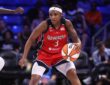 Washington Mystics guard Rori Harmon driving the ball along the perimeter as Dallas Wings forward Awak Kuier uses her length to close down the lane defensively.