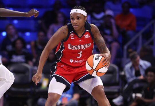 Washington Mystics guard Rori Harmon driving the ball along the perimeter as Dallas Wings forward Awak Kuier uses her length to close down the lane defensively.