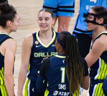 Jessica Shepard, Paige Bueckers, Alanna Smith, Odyssey Sims, and Arike Ogunbowale huddled tightly together on the court discussing a play during a timeout.