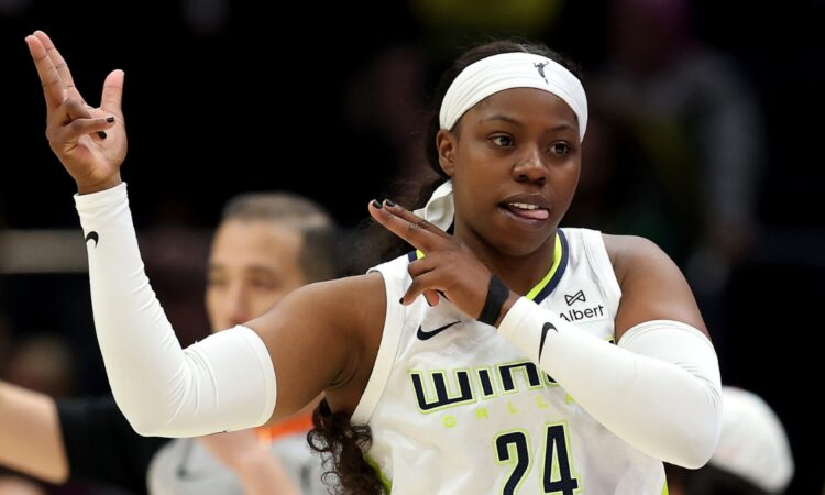 Dallas Wings guard Arike Ogunbowale celebrating a three-point basket during a game against the Seattle Storm at Climate Pledge Arena.