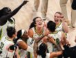 Dallas Wings players swarm Li Yueru and Aziaha James to celebrate a 93-92 comeback win over the Chicago Sky, with Paige Bueckers and Jessica Shepard joining the mob.