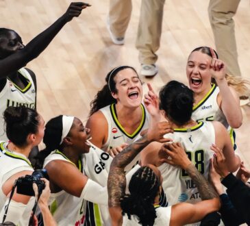 Dallas Wings players swarm Li Yueru and Aziaha James to celebrate a 93-92 comeback win over the Chicago Sky, with Paige Bueckers and Jessica Shepard joining the mob.