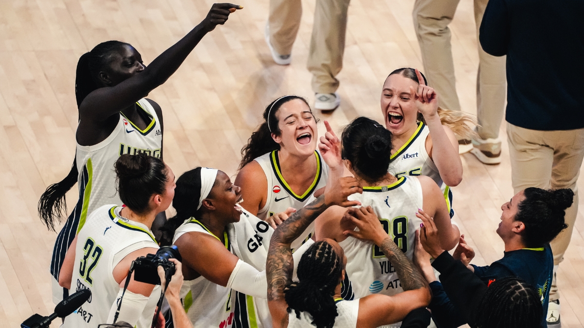 Dallas Wings players swarm Li Yueru and Aziaha James to celebrate a 93-92 comeback win over the Chicago Sky, with Paige Bueckers and Jessica Shepard joining the mob.