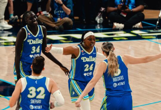 Dallas Wings players Awak Kuier, Jessica Shepard, Arike Ogunbowale, and Paige Bueckers celebrate during a WNBA game against the Las Vegas Aces at College Park Center in Arlington, Texas, on June 15, 2026.