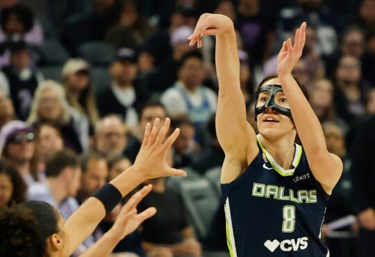 Dallas Wings forward Alanna Smith, wearing a protective face mask, shoots a 3-pointer over Golden State's Janelle Salaün.