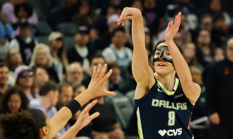 Dallas Wings forward Alanna Smith, wearing a protective face mask, shoots a 3-pointer over Golden State's Janelle Salaün.