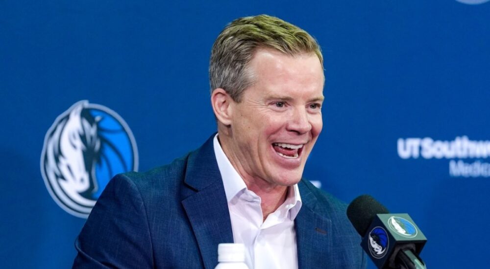 Dusty May smiles while answering questions at the podium during his introductory press conference as Dallas Mavericks head coach.