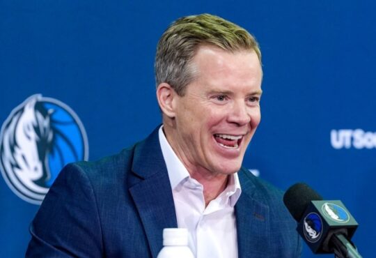 Dusty May smiles while answering questions at the podium during his introductory press conference as Dallas Mavericks head coach.
